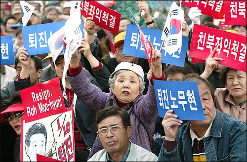 28일 오후 광화문 동화면세점 앞에서 열린 탄핵지지집회에서 참가자들이 태극기와 카드를 흔들며 '노대통령 퇴진'을 요구하고 있다. 